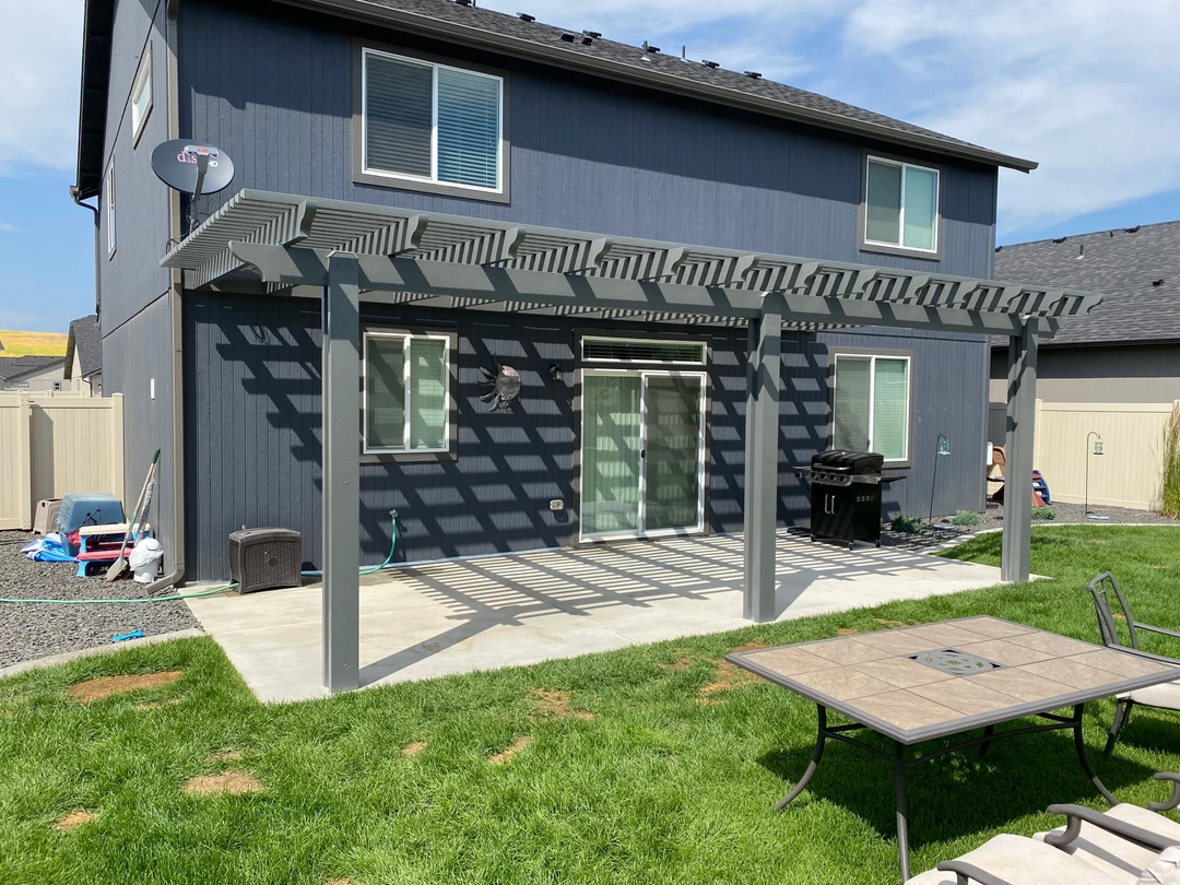 Concrete deck with blue pergola above it.