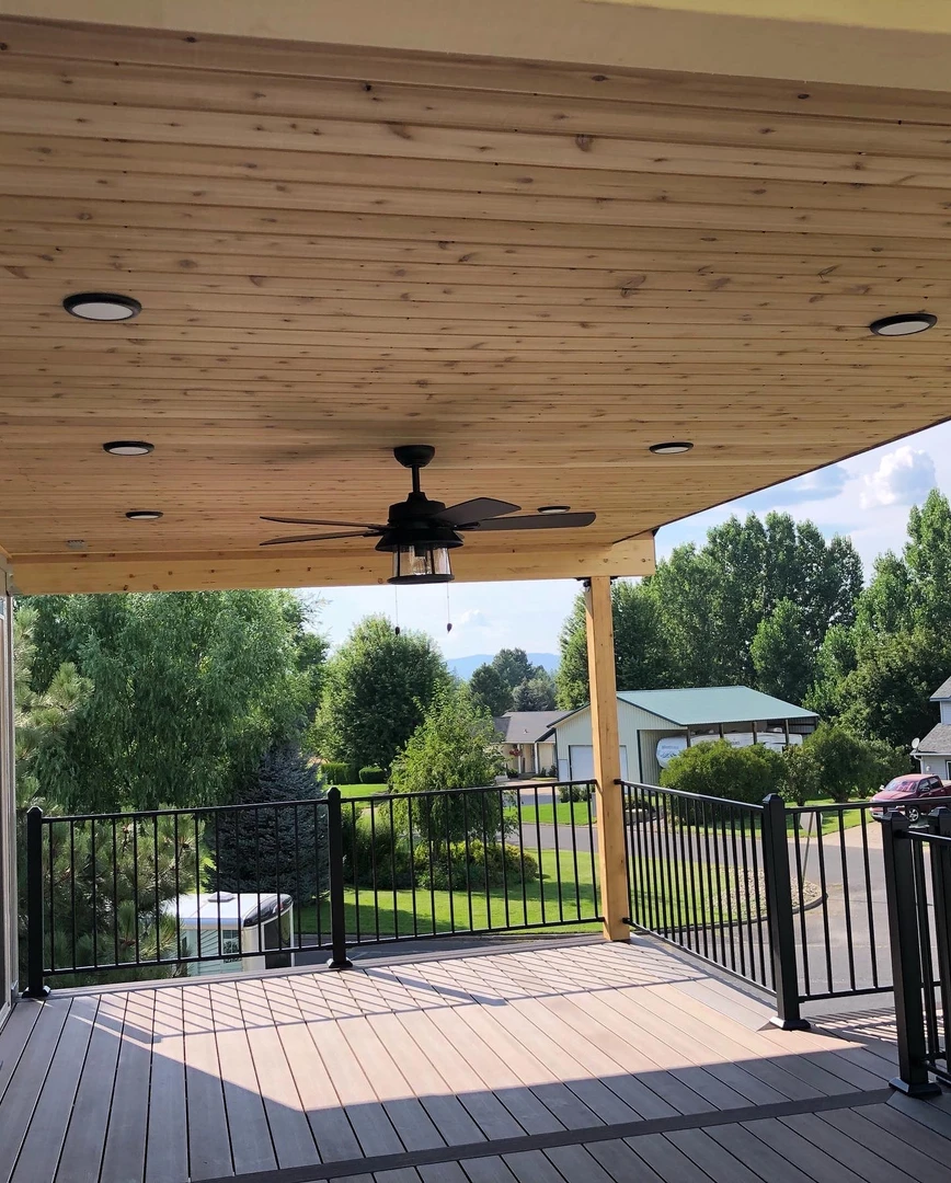 Deck with tongue and groove cover that has lights in it. Deck is surrounded by black railing.