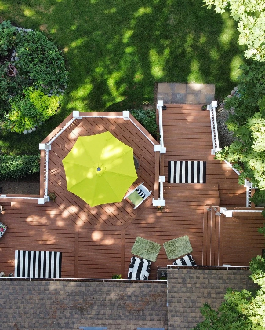 Brown deck with stairs and white railing.