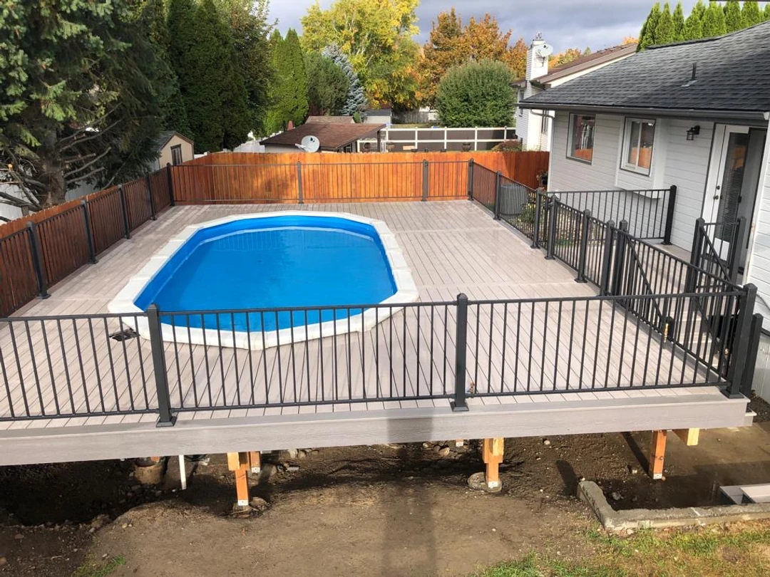 Deck with black railing and pool in the center.