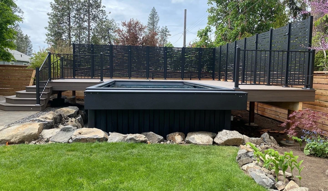Deck with pool in the center and stairs leading up to it. Privacy walls are around the deck.