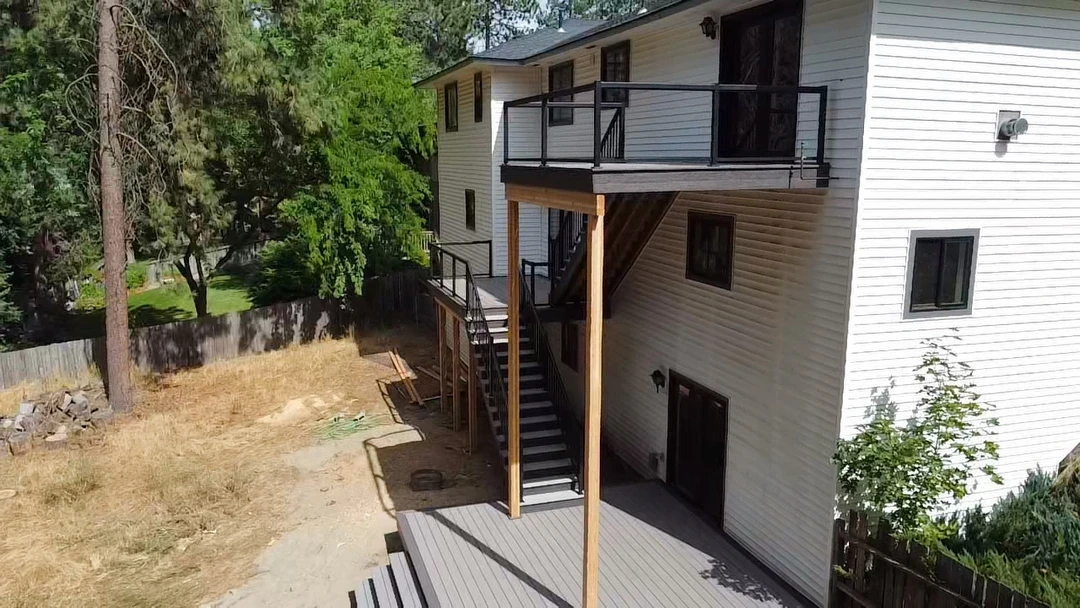 Deck with lots of stairs leading up to it and glass railing.