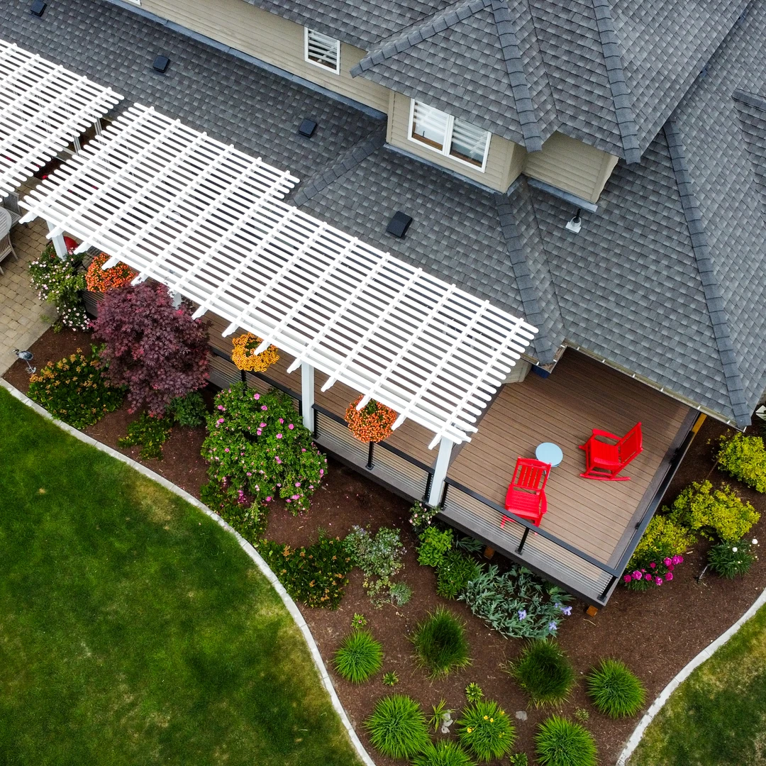 Deck with black cable rail and white pergola.