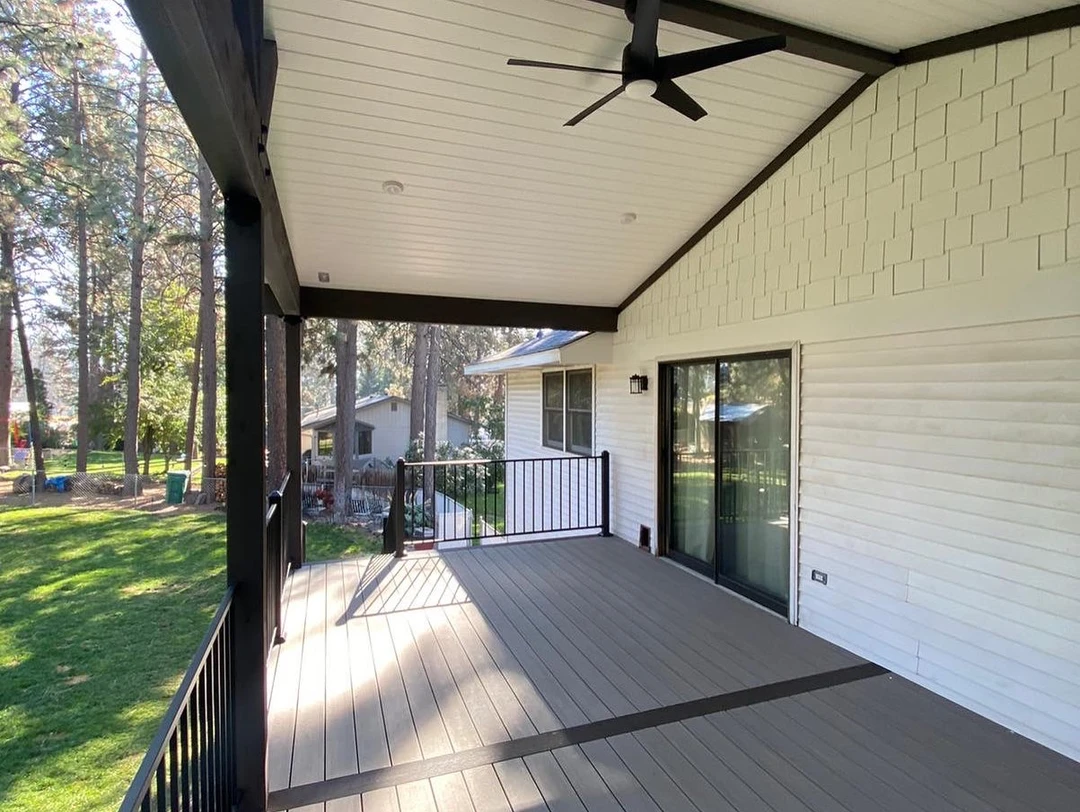 White house with lighter deck and white ceiling of a tongue and groove cover.