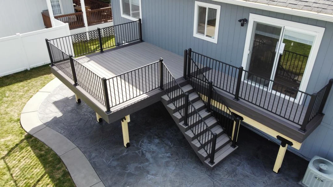 Light deck with stairs and black railing.