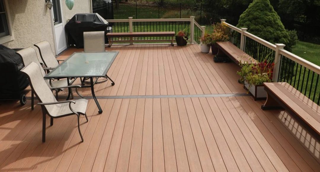 Brown deck with black railing and benches.