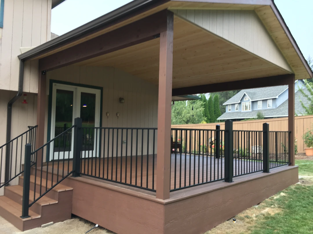 Tongue and groove cover with brown deck and black railing.