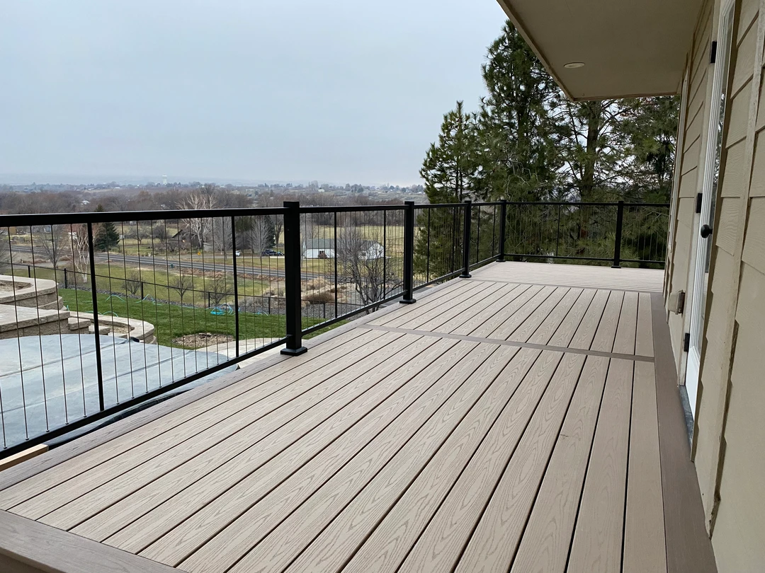 Tan deck with black railing over looking the city.