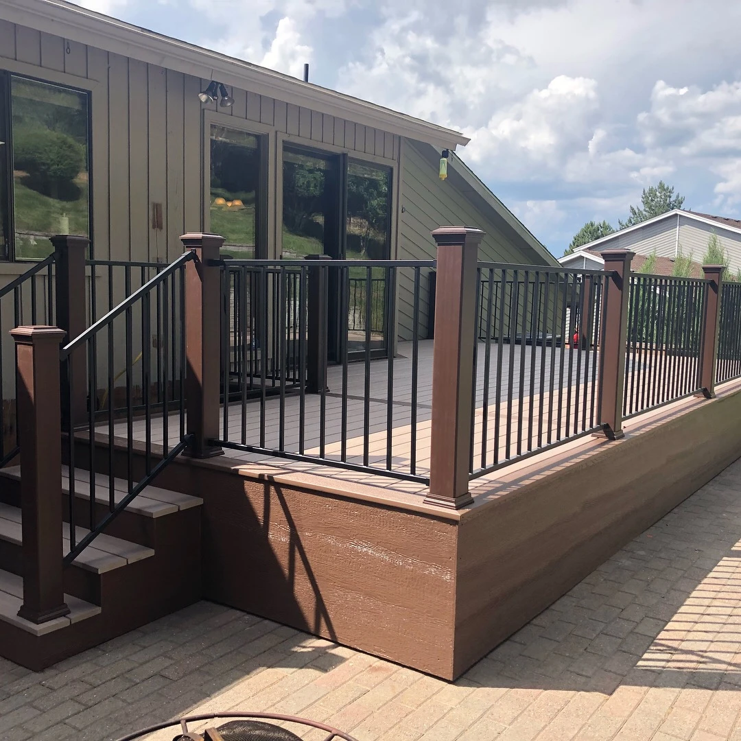 Brown deck with black railing.