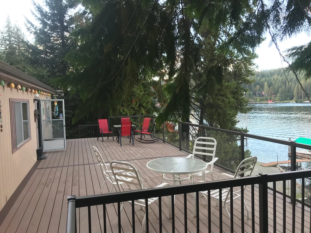 Brown deck with black railing and furniture on it.