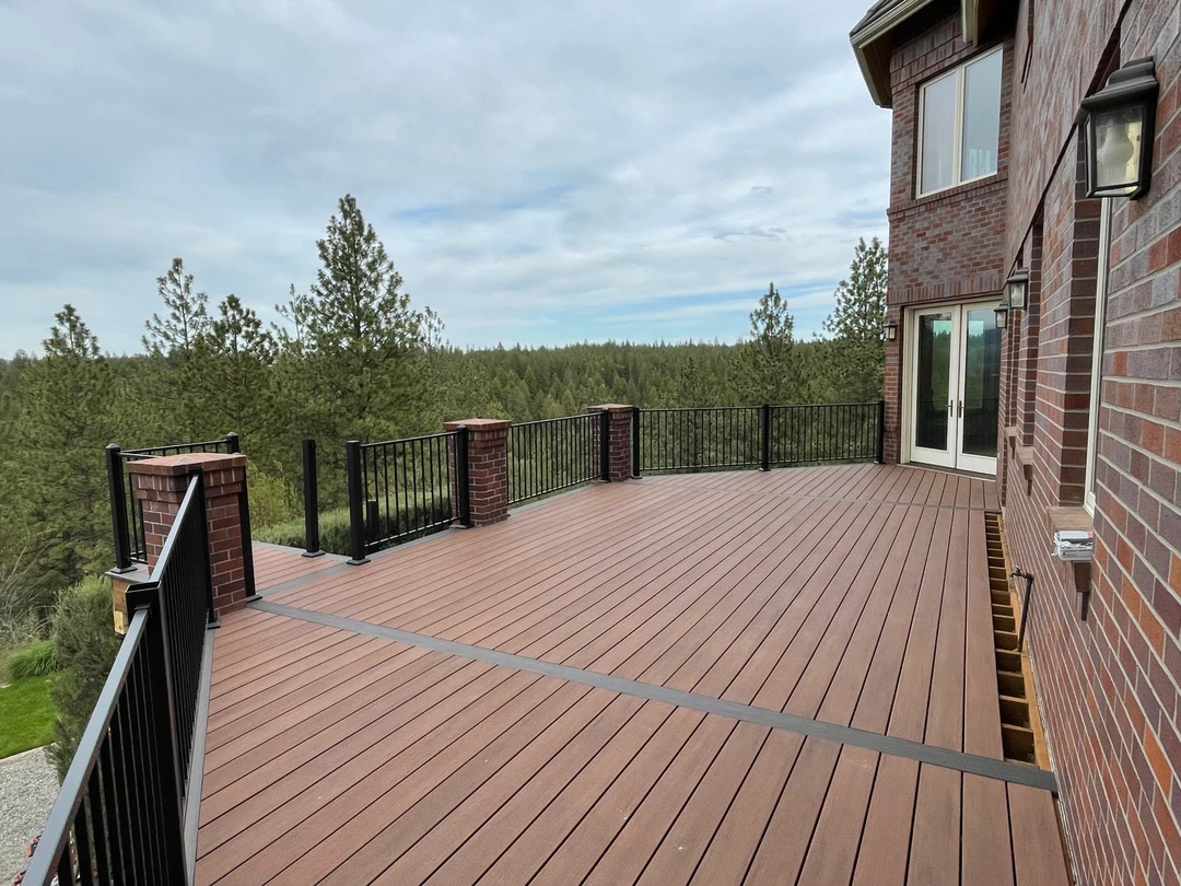 Brown deck with black railing.