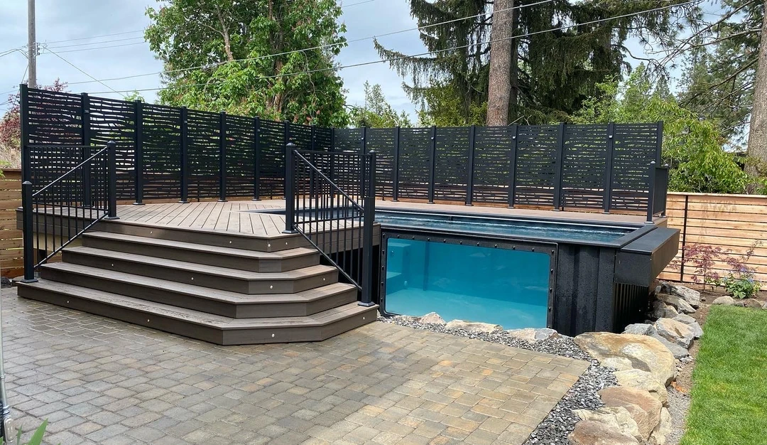 Wrap around deck around pool. Wide stairs off the deck. Deck lighting installed on stairs. Powder coated aluminum privacy wall with cool pattern. Mod pool installed with deck around it. 