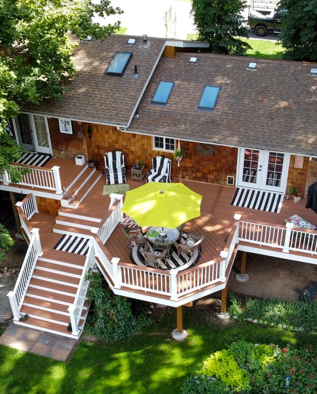 Large brown deck with railing and lights. The deck enhances the home.